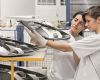 Two production workers carry out quality assurance